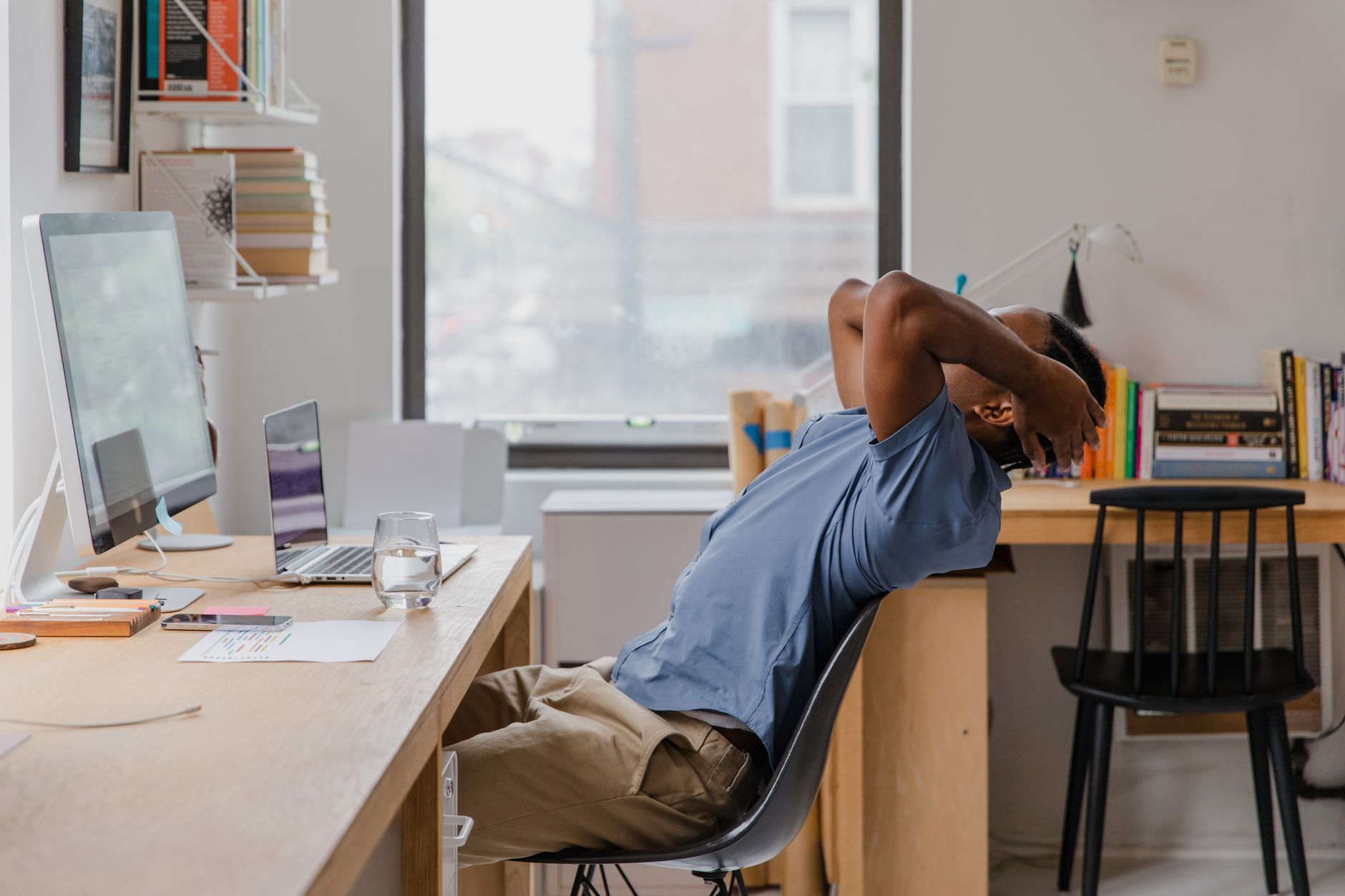 A man sits back in a chair at his home office, indicating a relaxing work environment.