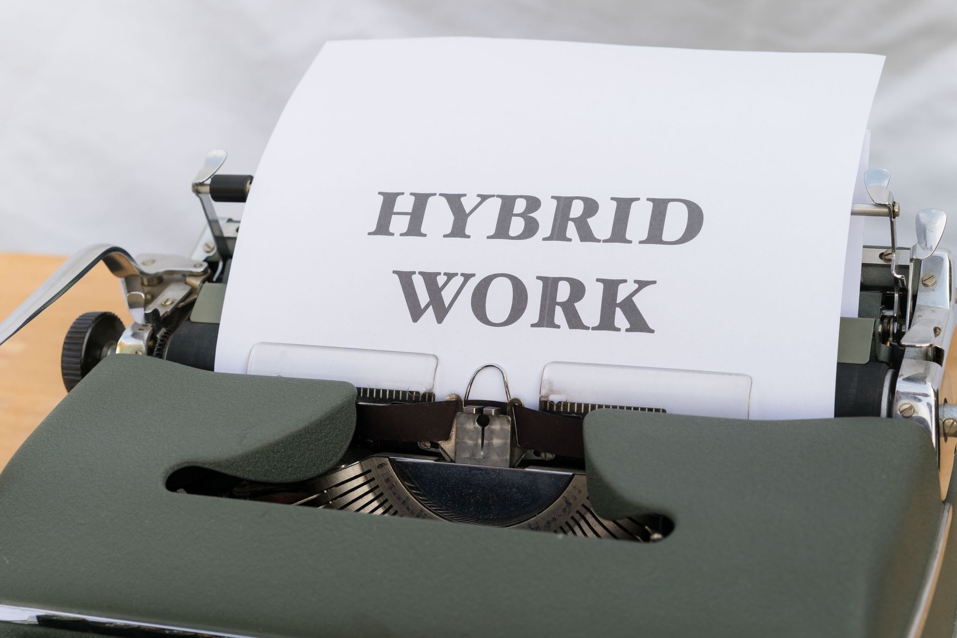 Close-up of a vintage typewriter with the text 'Hybrid Work' on paper, symbolizing modern work trends.
