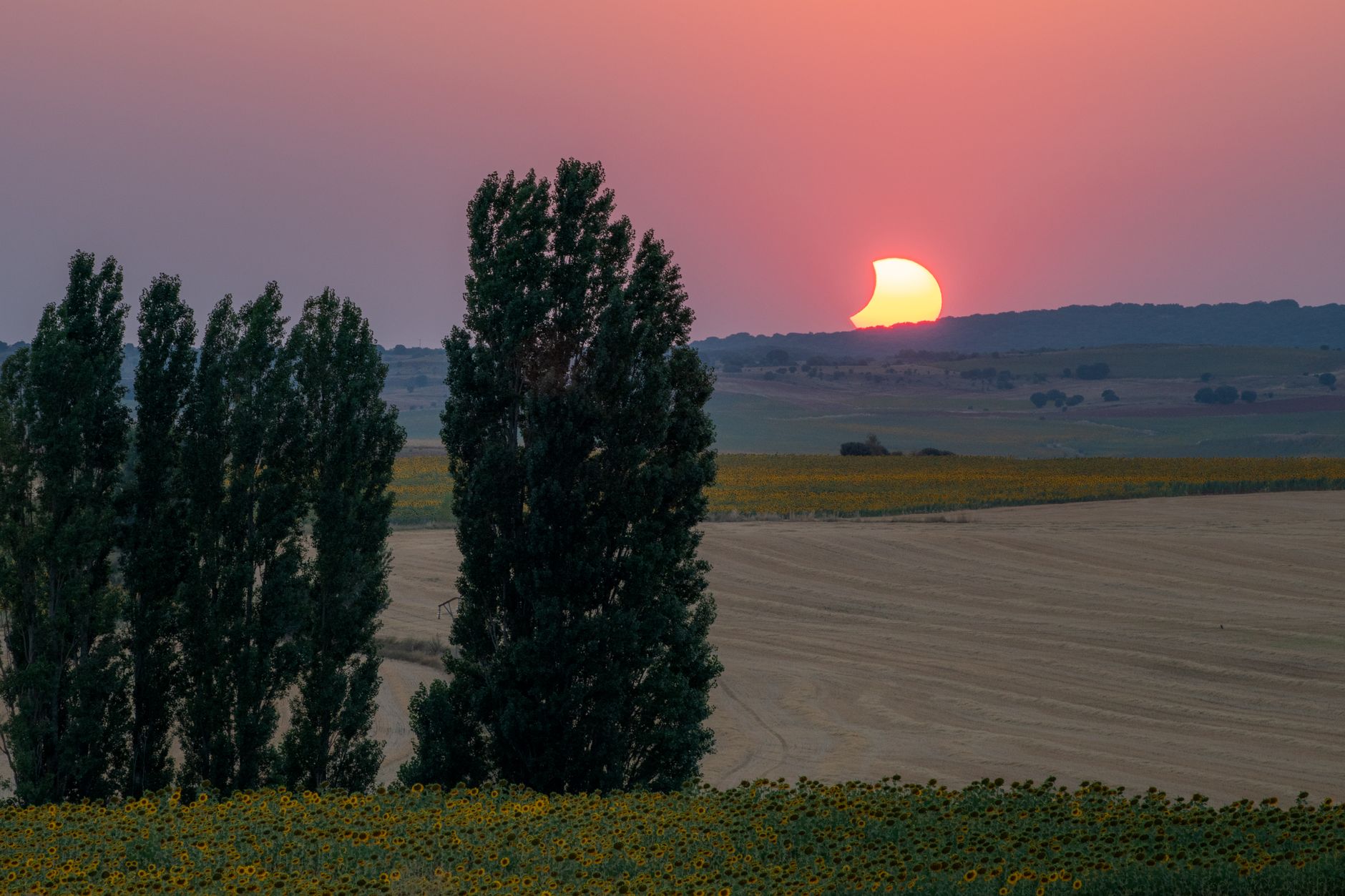 Stunning view of a solar eclipse setting over the fields of La Seca, Spain, creating a captivating silhouette effect.