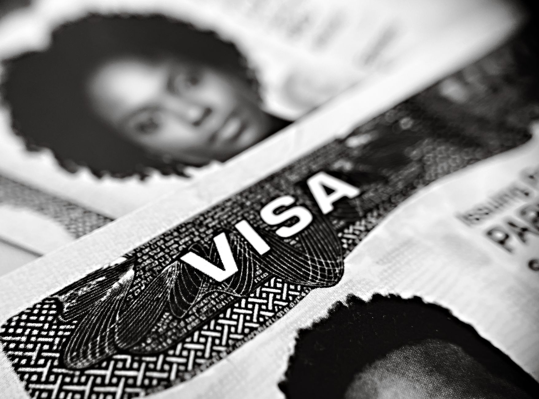 Black and white close-up of a visa document featuring a partial portrait and visa text.